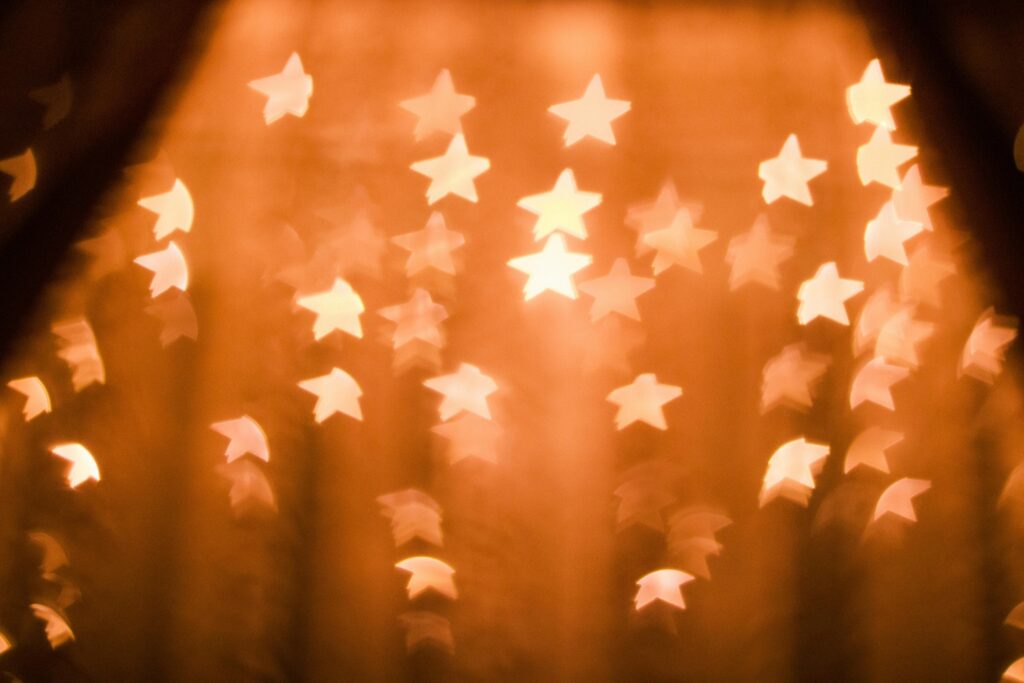 A warm, blurred star bokeh effect providing a festive abstract background.