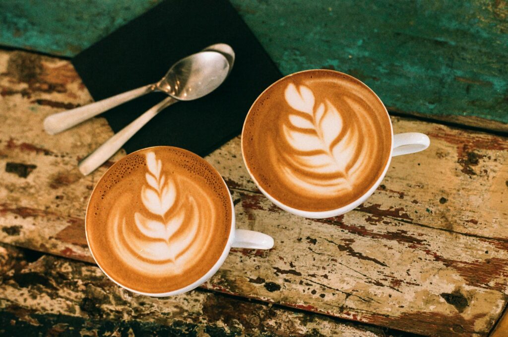 Café latte art on rustic table in Paris, capturing warm coffee moments.