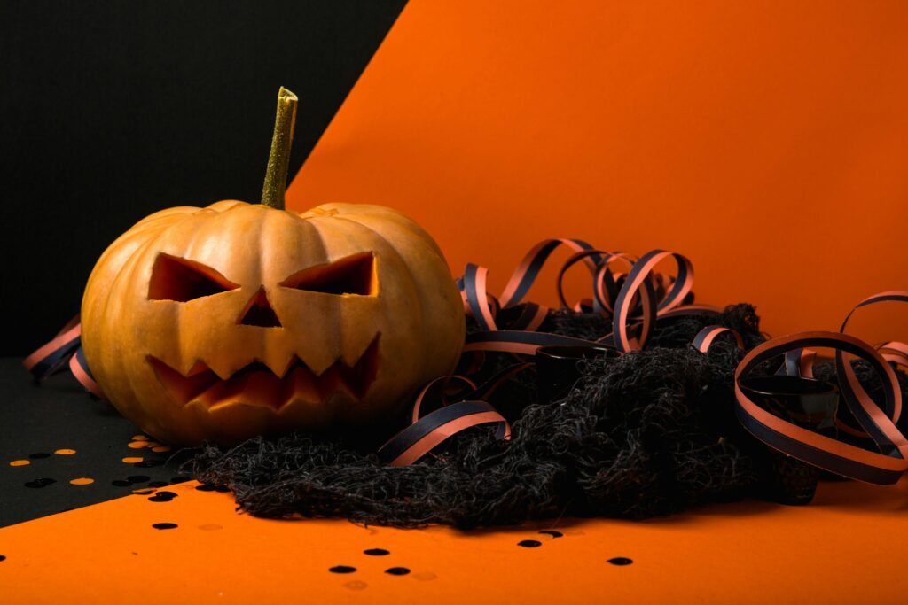 Spooky carved pumpkin with black and orange ribbon, perfect for Halloween decor.