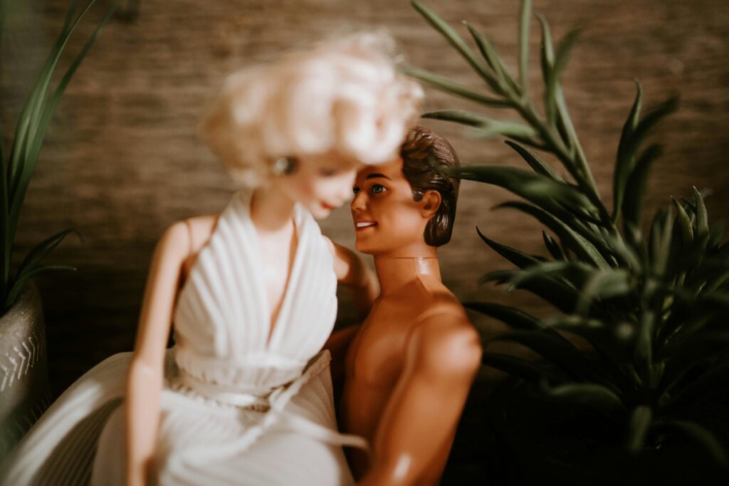 Romantic scene with dolls embracing, surrounded by indoor plants.