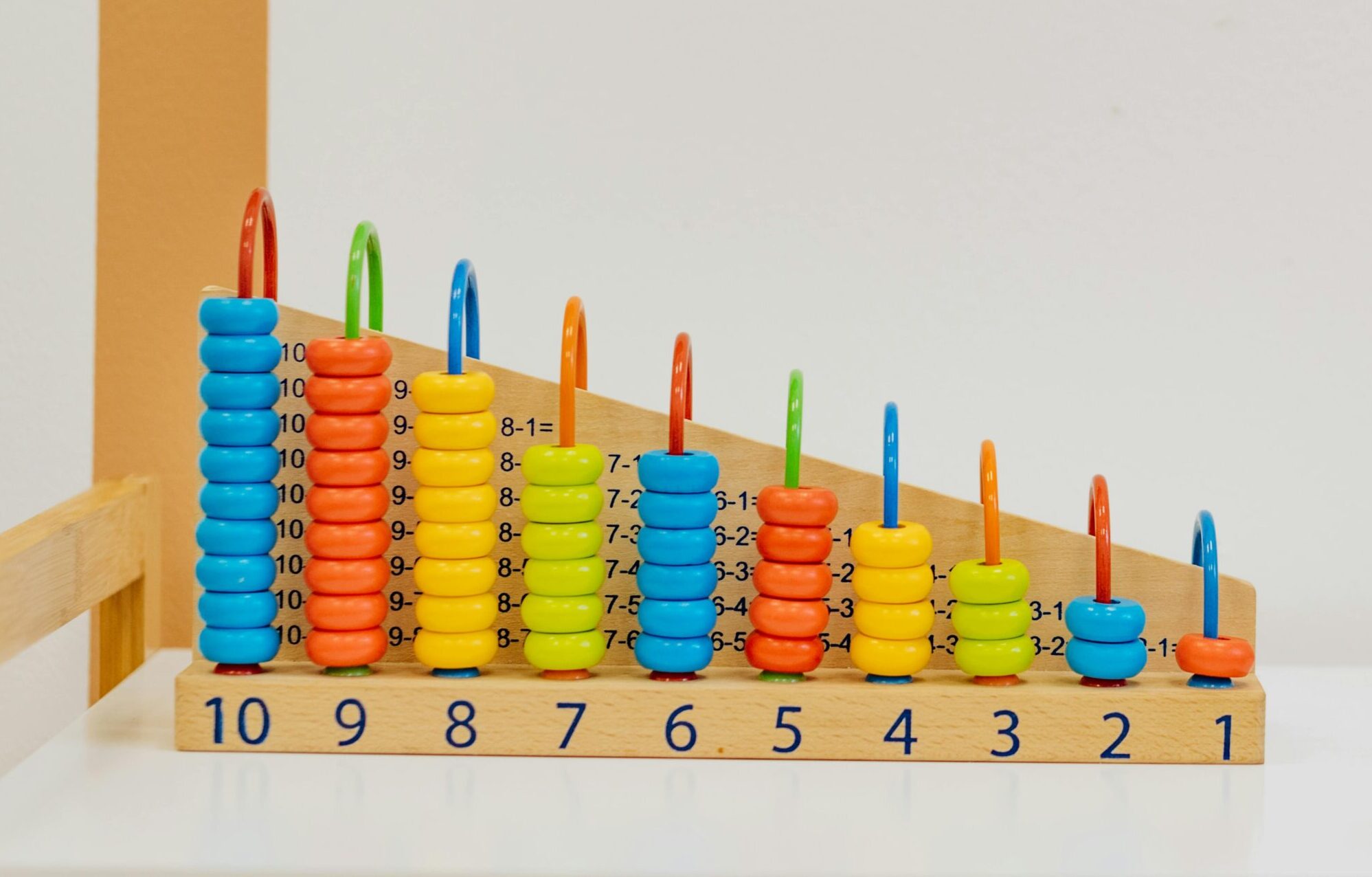 Close-up of a colorful wooden counting toy with numbers and shapes, perfect for preschool learning.