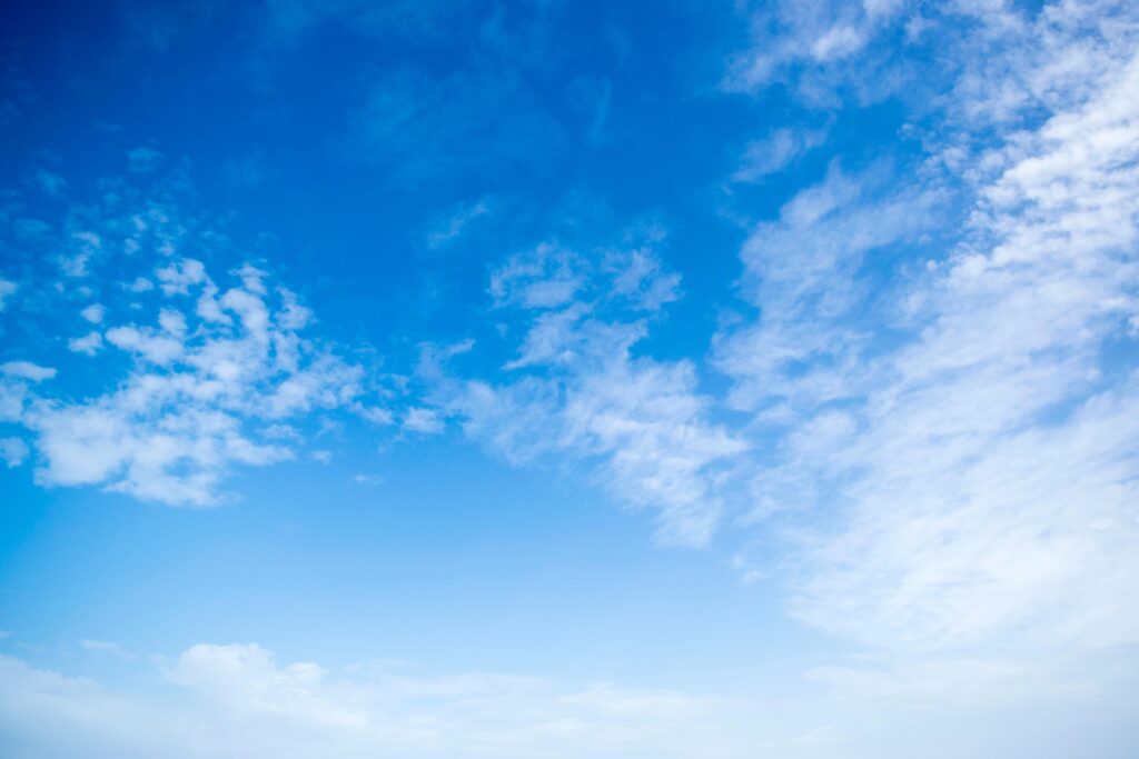 A serene view of a bright blue sky with fluffy white clouds, perfect for backgrounds.