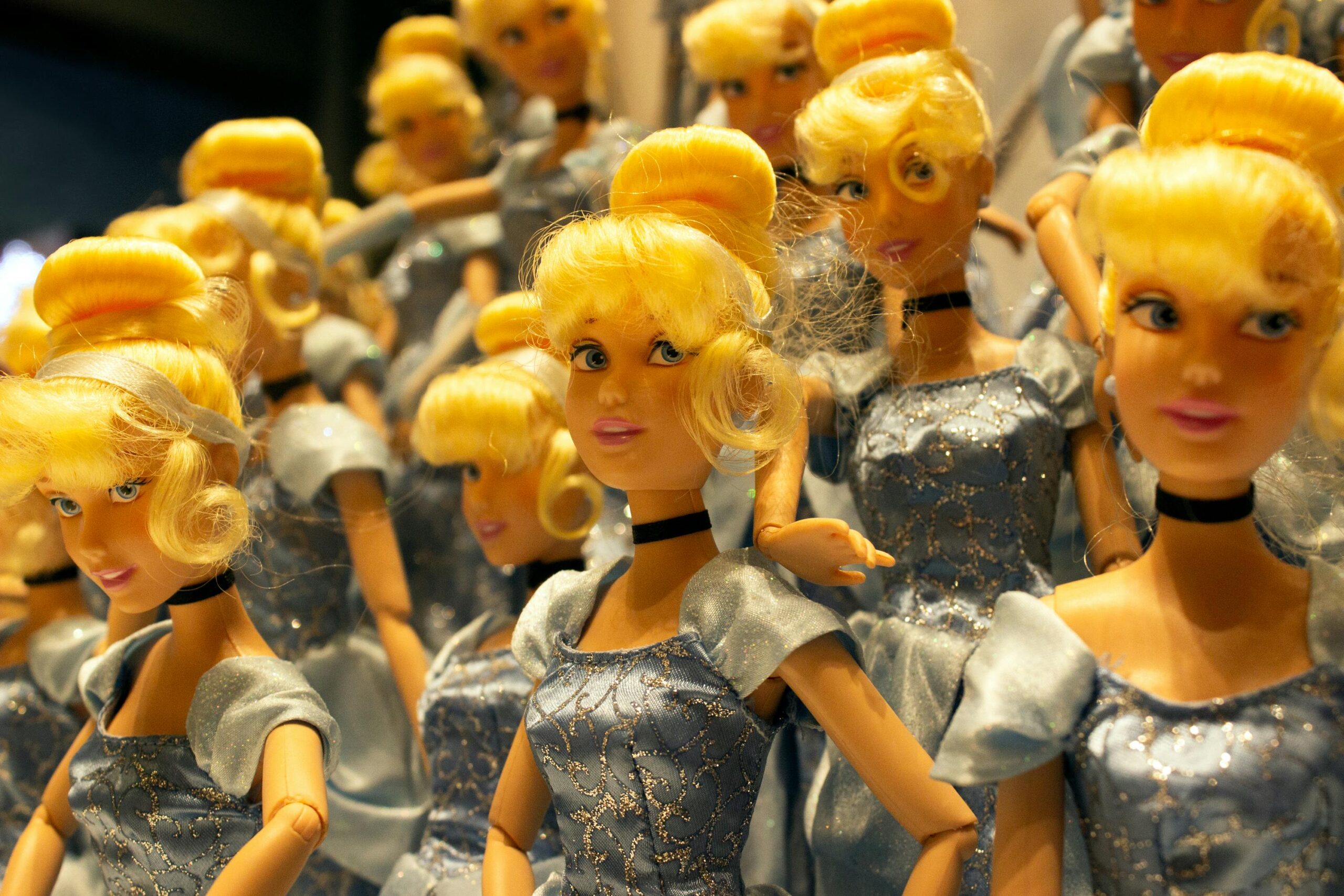 Close-up of multiple fashion dolls wearing elegant blue gowns, perfect for toy and fashion themes.